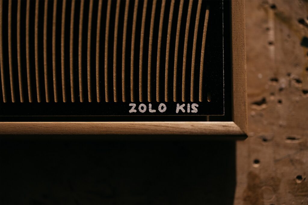 Hariko by Zolo Kis — close-up of the Zolo Kis signature beside milled lines and the frame