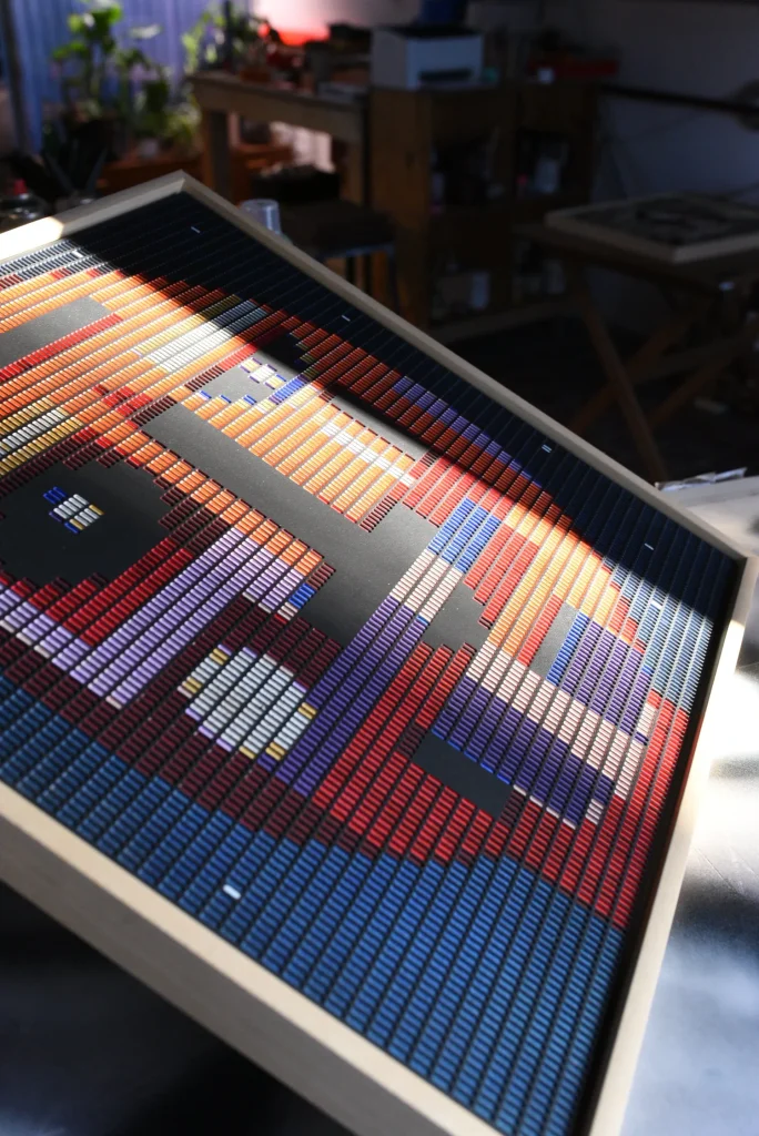 Starboy edition S by Zolo Kis — framed face in orange, purple and blue on a studio worktable