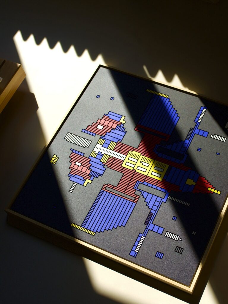 Zolo Kis artwork — framed blue, red and yellow spacecraft in strong sunlight