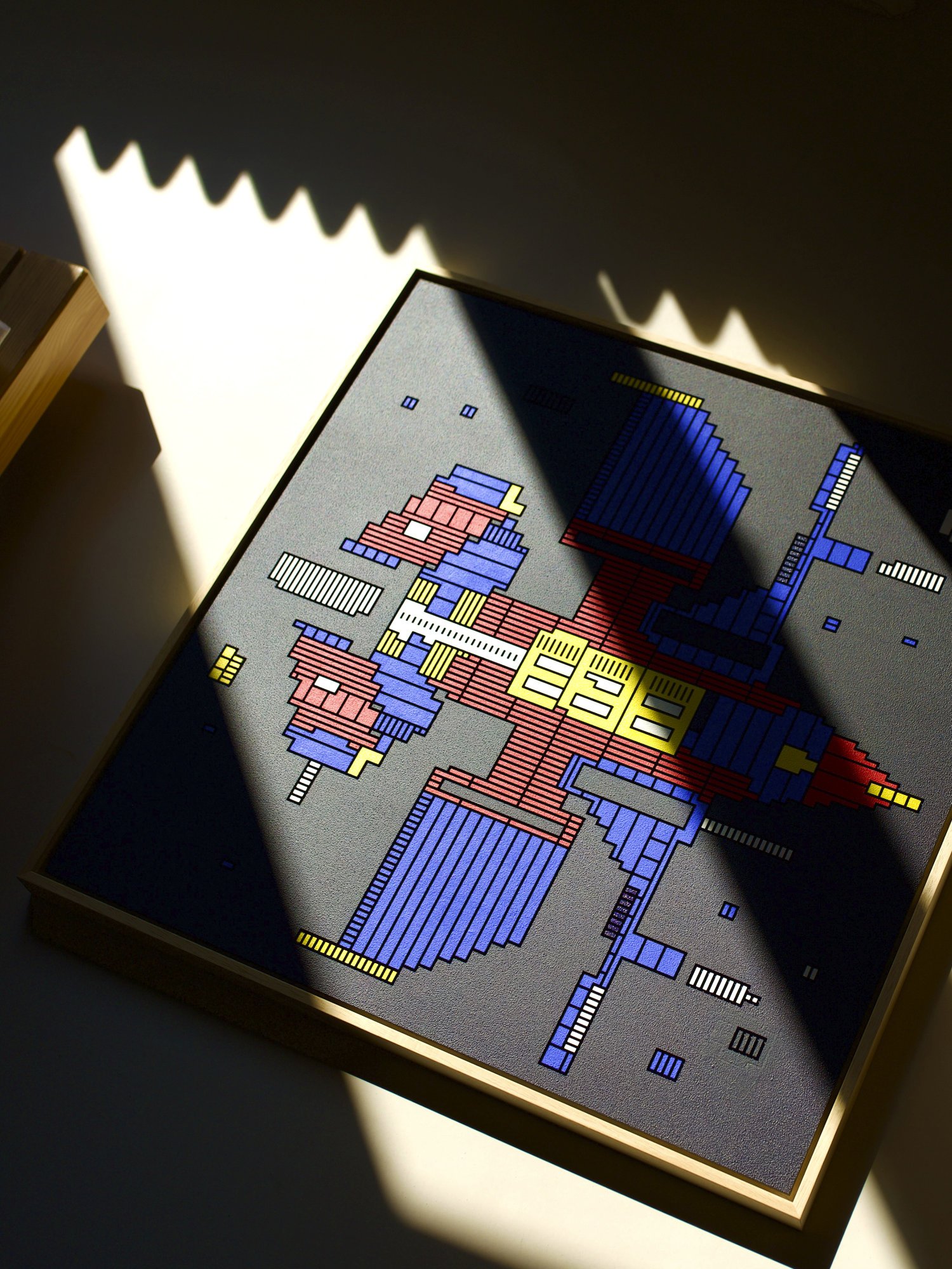 Zolo Kis artwork — framed blue, red and yellow spacecraft in strong sunlight