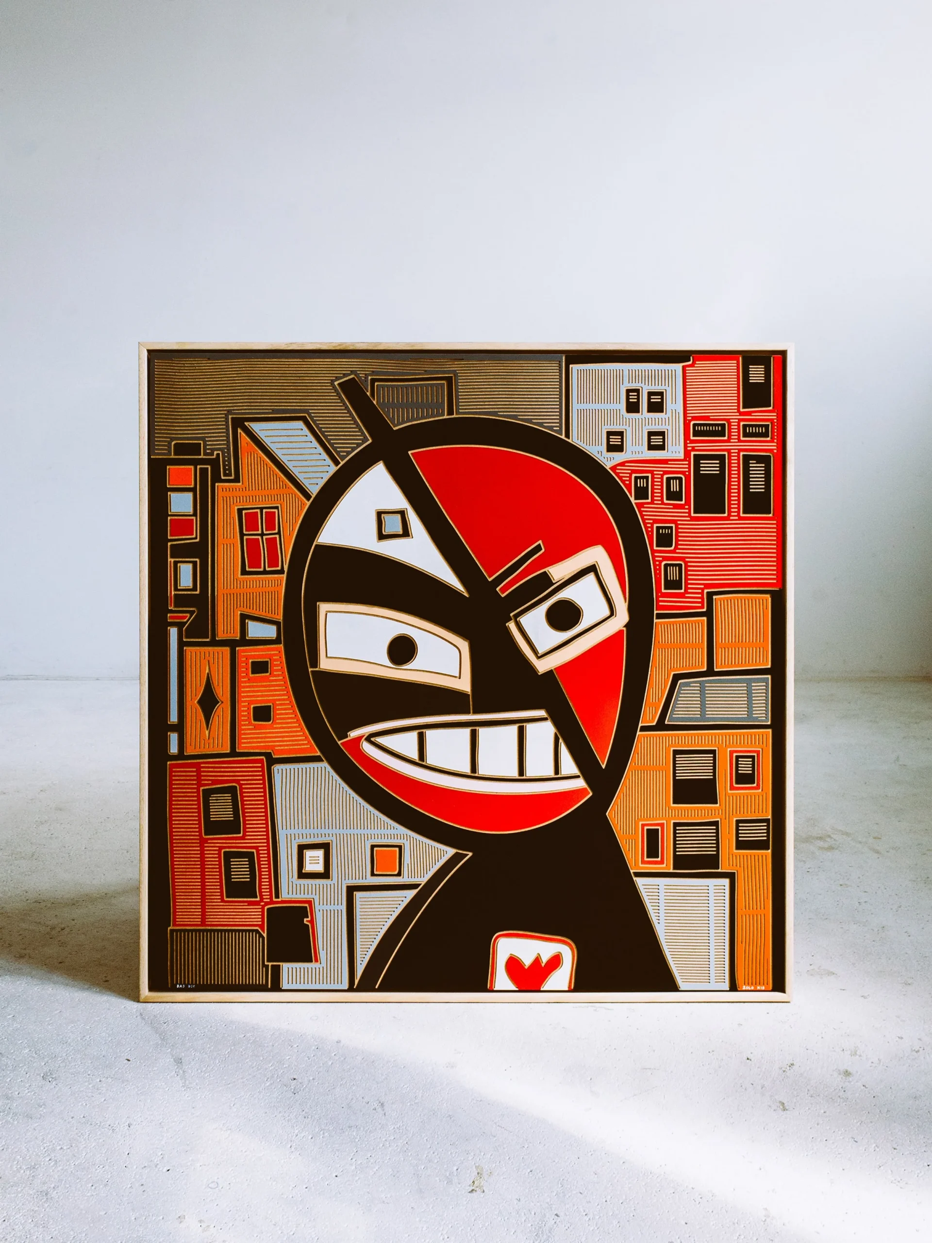 Bad Boy by Zolo Kis — framed red, white and black face with a broad grin and orange background