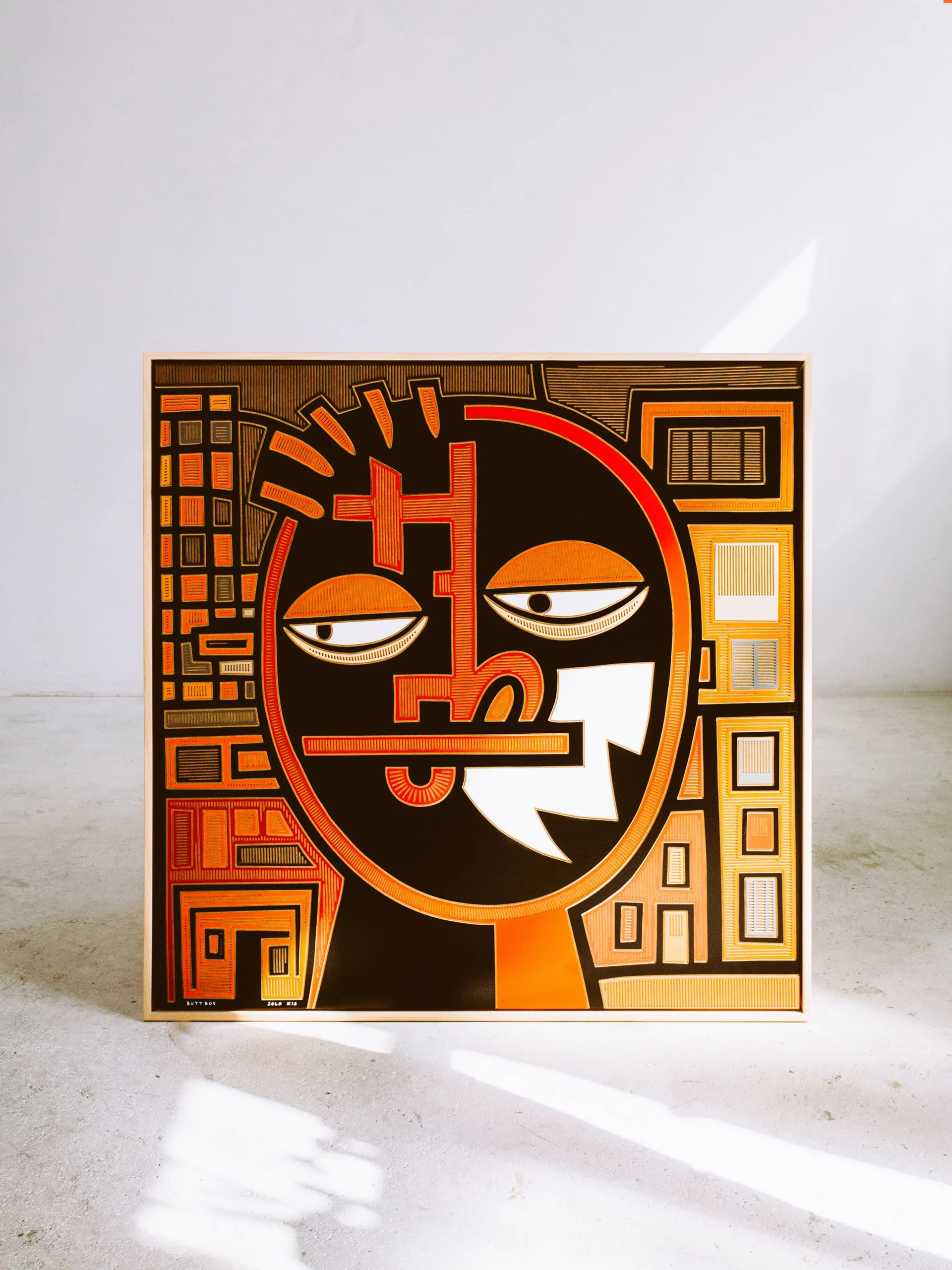 Butt Boy by Zolo Kis — framed black, white and orange face with half-closed eyes and a background