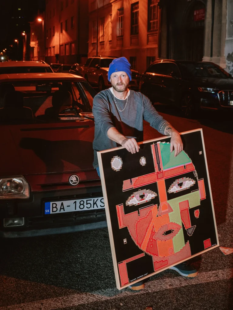The Captain of the Spaceship by Zolo Kis — a person holding the framed portrait beside a car at night