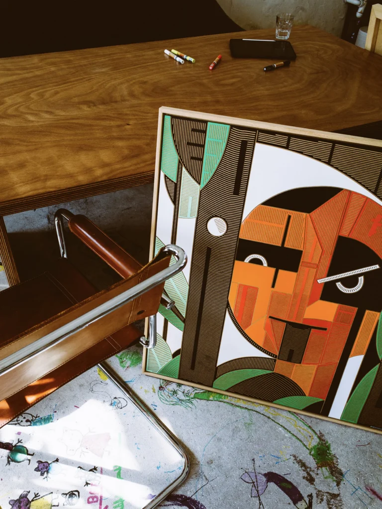 Oldschooler by Zolo Kis — the framed portrait leaning beside a chair and wooden table