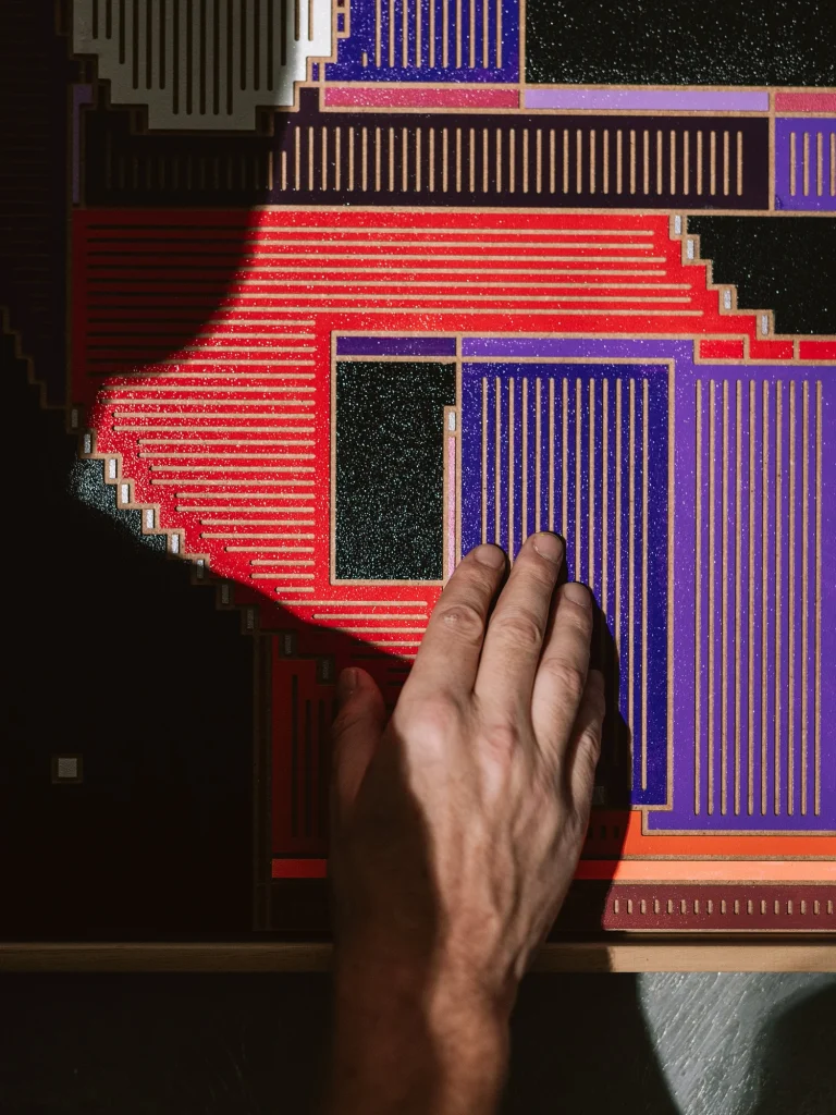 Starboy by Zolo Kis — a hand touching the purple and red milled relief surface